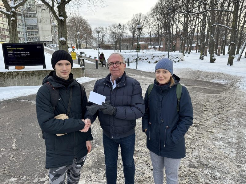 Klubbens medlem i midten gir to unge ukrainere som stod i kø ved Fattighuset i Oslo, matkort fra KC Oslo.